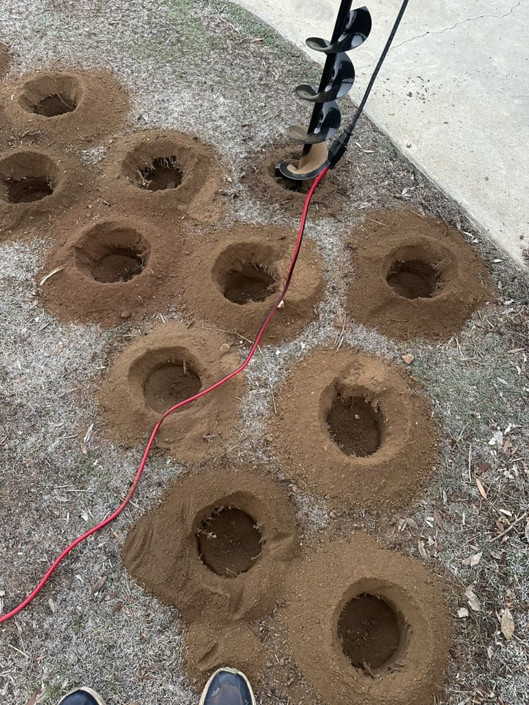 Rows of 4 inch auger holes drilled for planting Kurapia plugs
